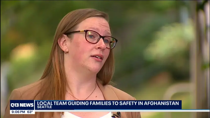 A photo of Brianna against an outdoor backdrop with a television news chyron that reads " Q13 NEWS: Local team guiding families to safety in Afghanistan."